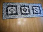 Quilted table runner, black, white, silver poinsettias