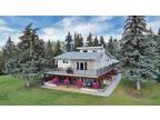 Peaceful living with this meticulously landscaped acreage 15 mins from Red Deer