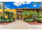 Welcome to this stunning white coral rock facade Spanish Courtyard style home w
