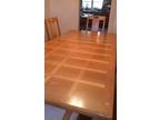 inlaid oak dining table with cushioned chairs