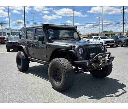 2014 Jeep Wrangler Unlimited Sport is a Grey 2014 Jeep Wrangler Unlimited Sport Car for Sale in Southaven MS