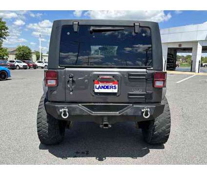 2014 Jeep Wrangler Unlimited Sport is a Grey 2014 Jeep Wrangler Unlimited Sport Car for Sale in Southaven MS